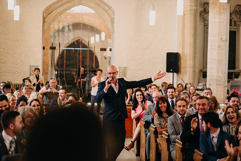 singer standing in the middle of the aisle in the church singing 