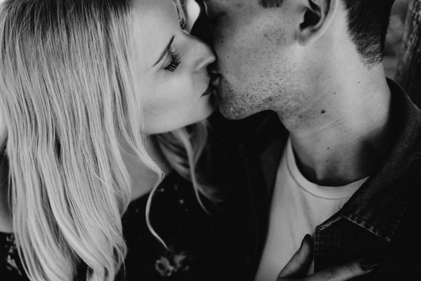 black and white photo close up of girl and boy kissing 