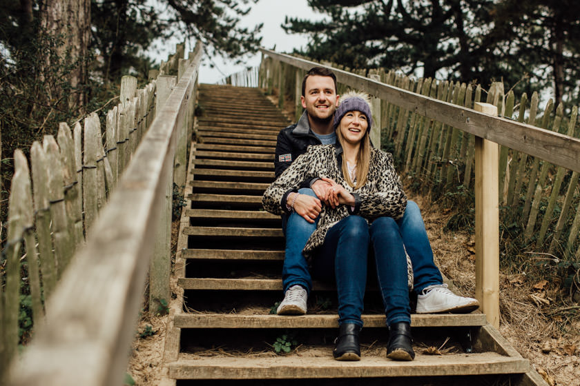couple sitting on stairs on a beach in norfolk