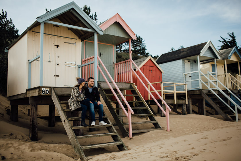 couple sitting on a steps of a beach hut on th beach