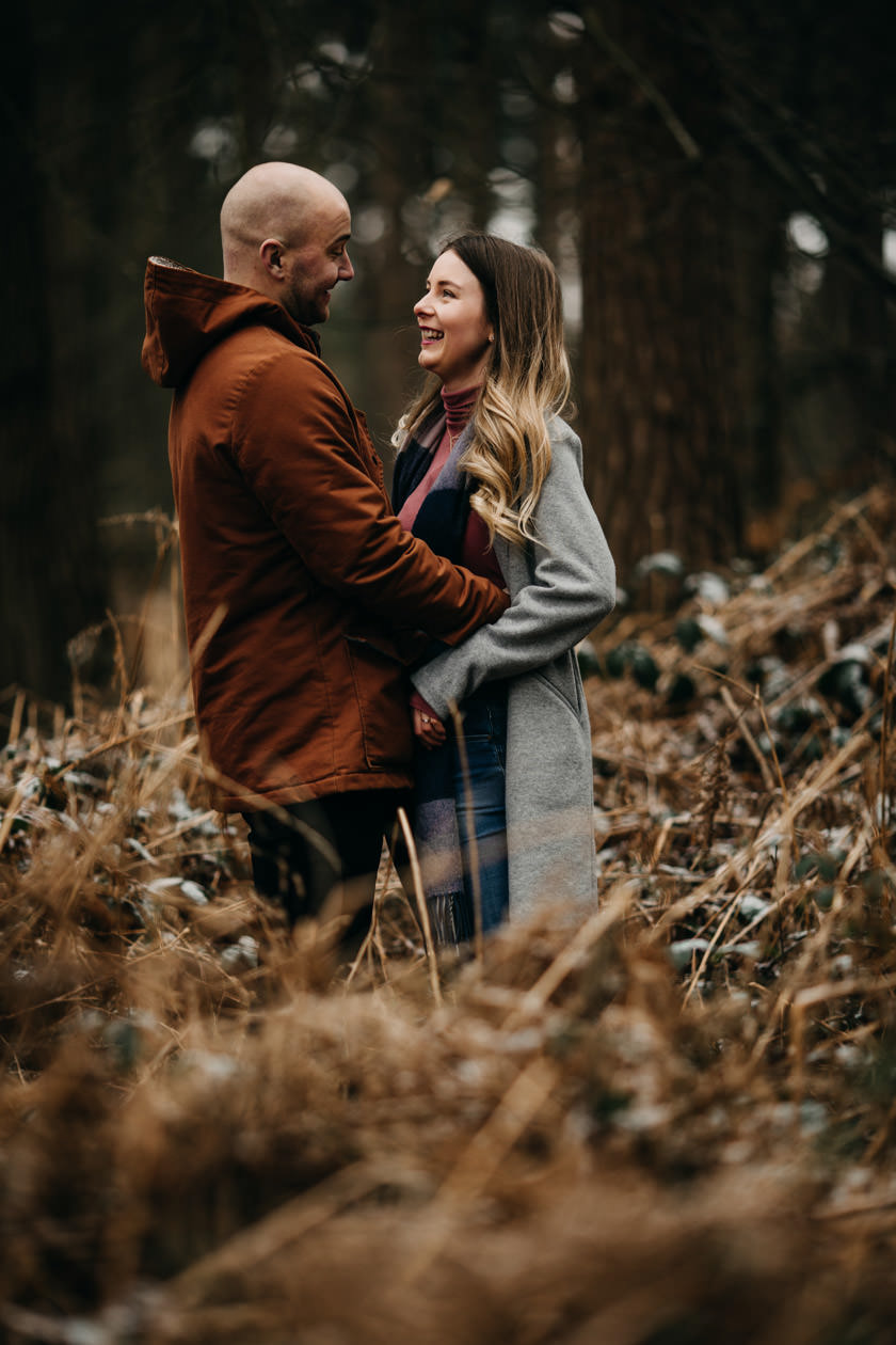 girl and boy looking at each other and smiling at Pre wedding shoot at Harlestone Firs