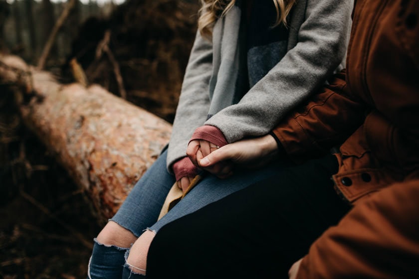close up of boy holding girls hand with engagement ring on 